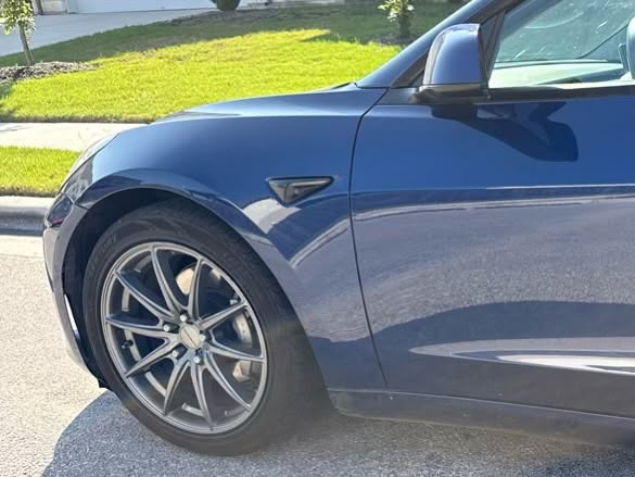 Close-up of a blue car front wheel and fender